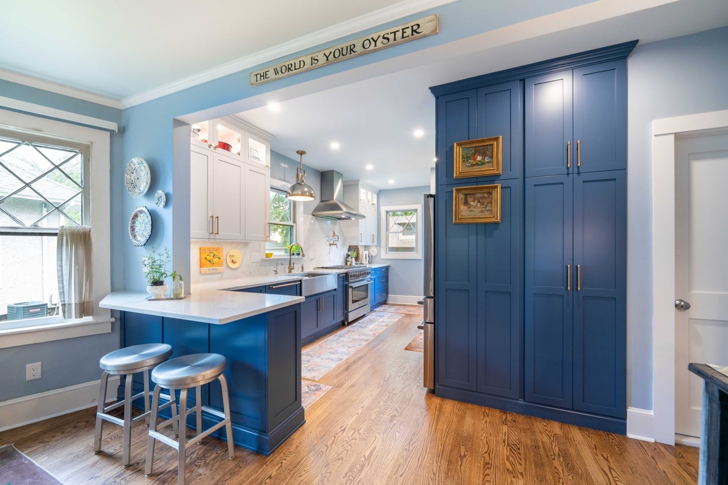 A kitchen with blue cabinets and a bar

AI-generated content may be incorrect., Picture