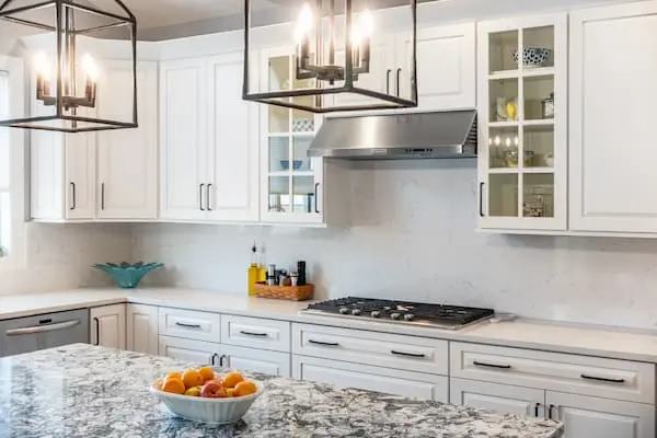 Modern remodeled kitchen with white cabinets, white countertops and gray island