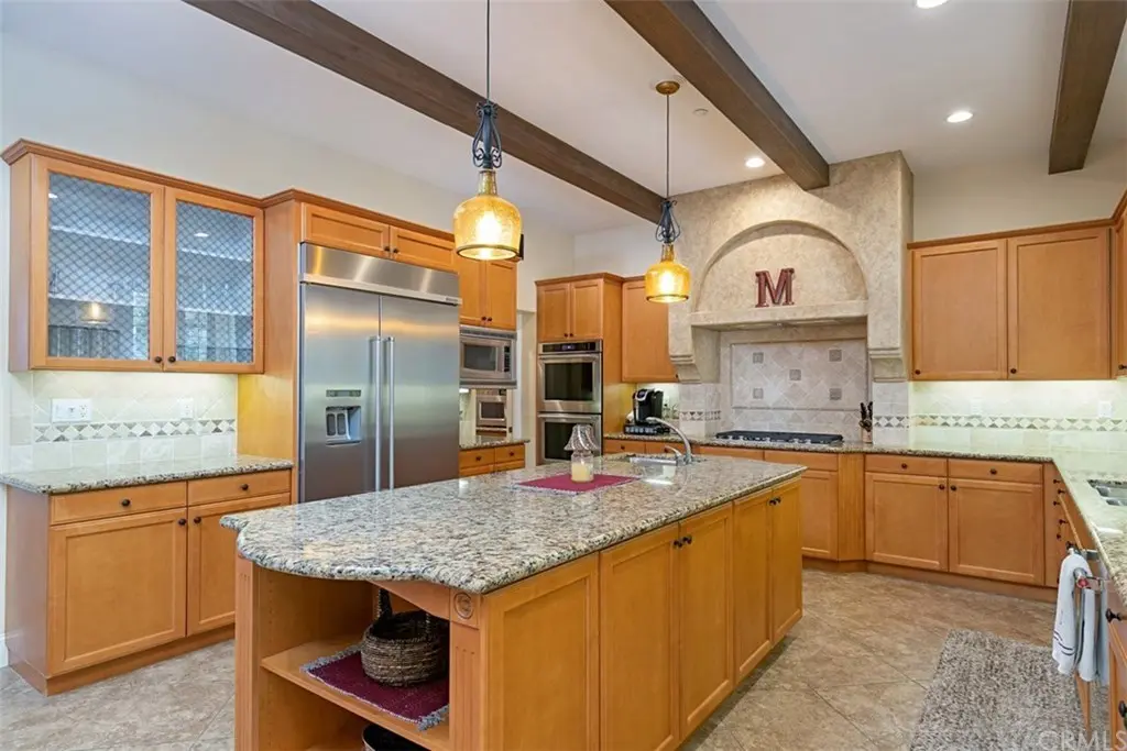 outdated kitchen with orange cabinets and speckled gray stone countertops