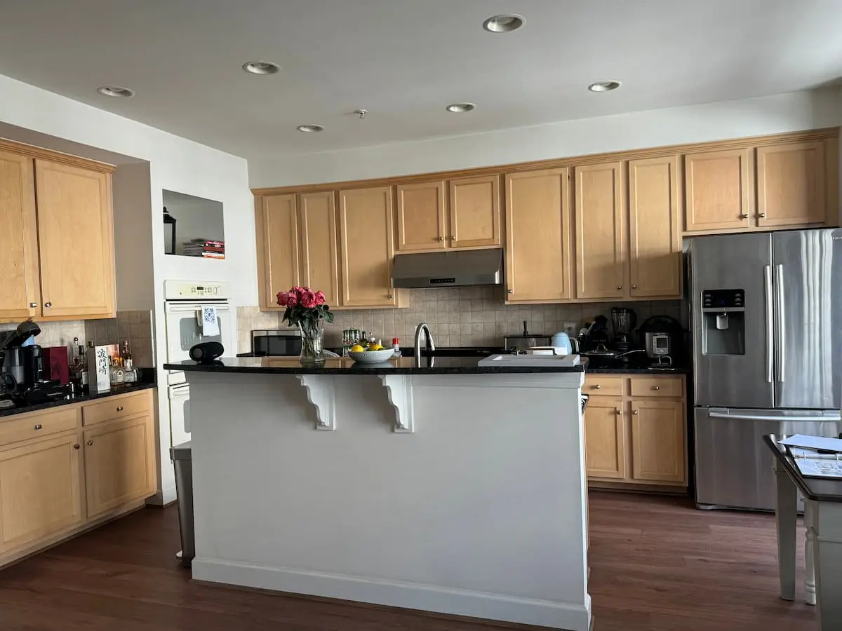 outdated kitchen with beige cabinets and black countertops