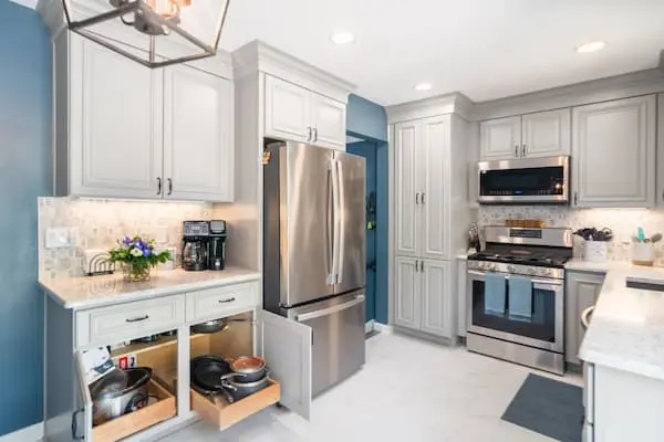white kitchen cabinets with pull out drawers and aqua blue walls