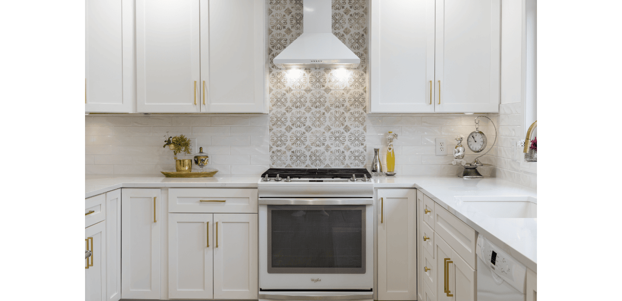 White shaker cabinet remodeling featuring gold hardware, white quartz countertops, and a decorative patterned tile backsplash above a white gas range