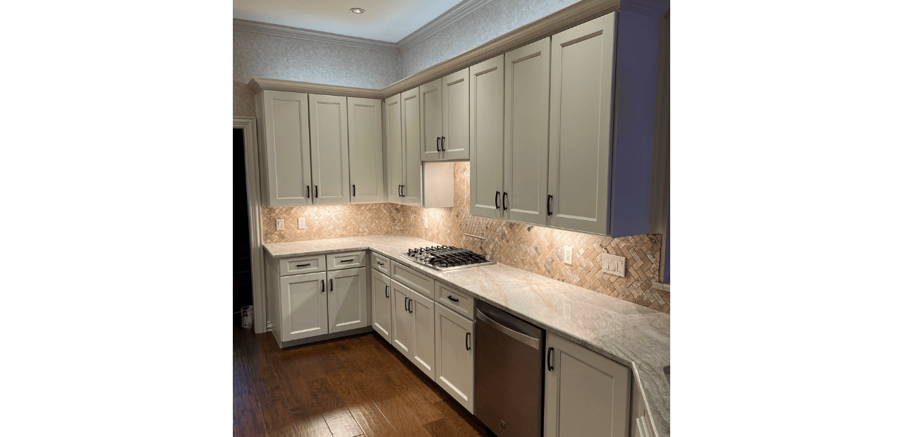 Professional kitchen cabinet redooring in Grapevine, TX featuring light gray Shaker-style cabinets, natural stone countertops, and herringbone tile backsplash.