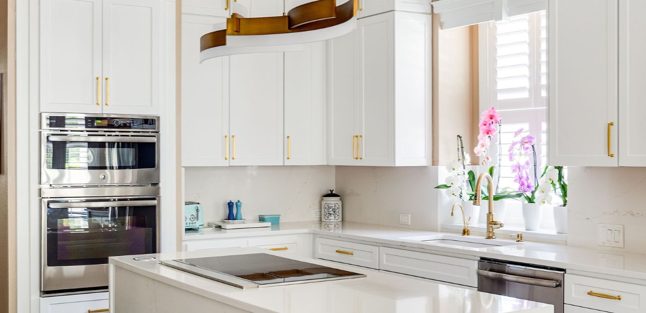 White shaker kitchen in Celebration FL with stacked cabinets, quartz countertops and waterfall island by kitchen Tune Up Orlando