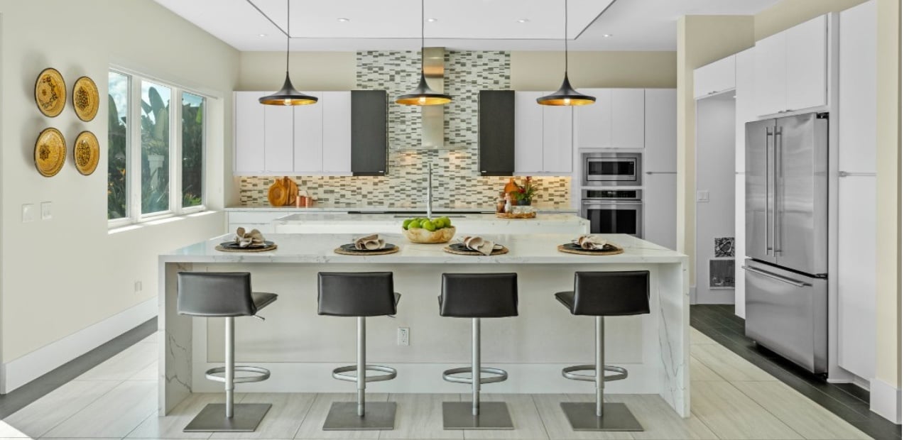 Cold contemporary kitchen in Lake Nona FL with high gloss white cabinets and black and white design