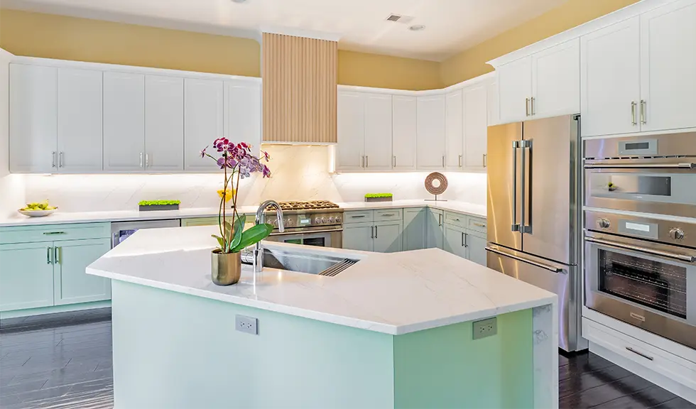 Full view of a two tone kitchen and stainless steel appliances with sink in the island. 