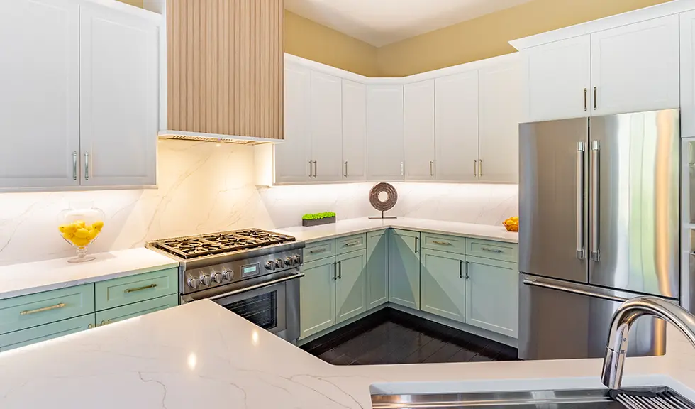 Close up view of two tone kitchen with stainless steel gas stove and fridge 